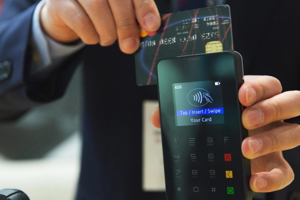 ضيف يدفع ببطاقته على جهاز دفع لاتلامسي
